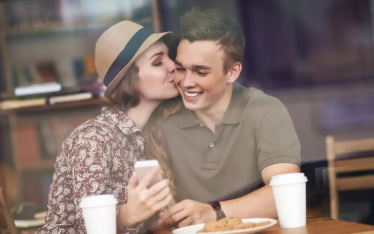 Zakochana para podczas randki w kawiarni, uśmiechnięci i bliscy sobie po udanym wydarzeniu typu speed dating. Romantyczna atmosfera, kawa i ciasteczka podkreślają sukces randek na żywo i możliwość poznania bratniej duszy w krótkim czasie.