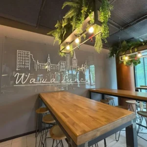 stół w restauracji wawa lunch, widoczne logo na szarej ścianie, oświetlenie oraz rośliny w restauracji, Speed dating u Amora Warszawa minirandki, spotkania dla singli, tinder, dreamdate, upoluj singla