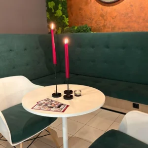 kawiarnia, na stole stoją dwie zapalnone różowe świece, biały stół, białe krzesła, Speed dating u Amora Warszawa minirandki, spotkania dla singli, tinder, dreamdate, upoluj singla