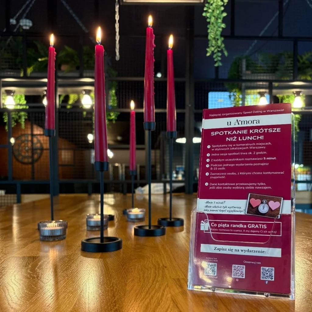 na stole w kawiarni stoją świec które tworzą nastrój do rozmów i spotkań, świece w kolorze różonwym, szybka randka, miejsce spotkań singli speed dating u Amora, Warszawa