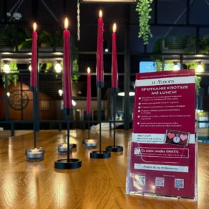 na stole w kawiarni stoją świec które tworzą nastrój do rozmów i spotkań, świece w kolorze różonwym, szybka randka, miejsce spotkań singli speed dating u Amora, Warszawa