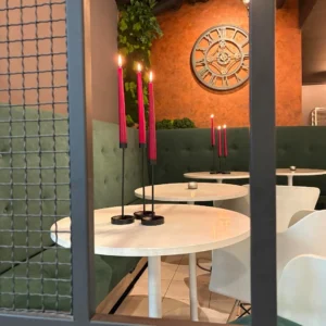 stoły w kawiarni, palące się świece, zegar na ścianie, nastrój, rozmowy, Speed dating u Amora Warszawa minirandki, spotkania dla singli, tinder, dreamdate, upoluj singla